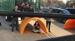 Virginia Tech students pose with Advanced Drainage Systems&apos; stormwater management products during an on-site exhibition at the school.