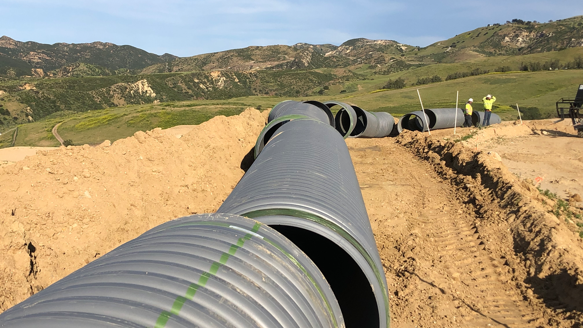 Large diameter stormwater pipe is staged and ready to be installed in the trench at Porter Ranch.