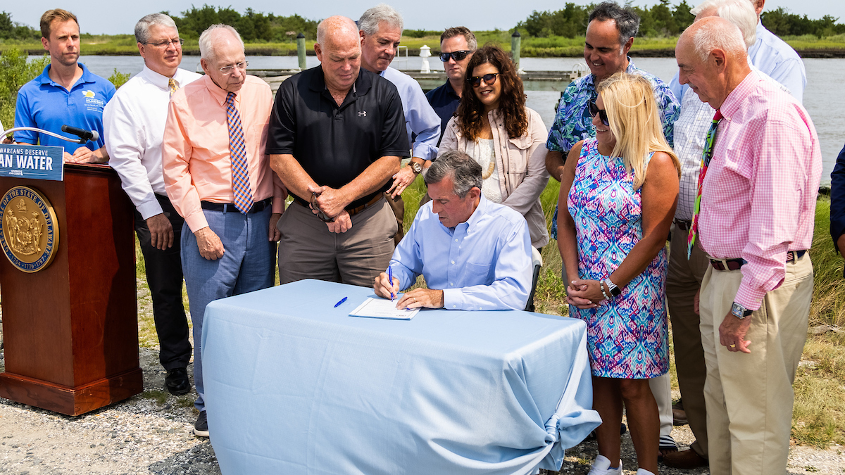 Delaware Governor John Carney, signing the Clean Water for Delaware Act during a public event.