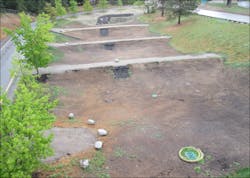 A catch basin at the low end of the tiered infiltration swale system allows excess stormwater to return to the piped system and ultimately to the outfall if the swale system is overwhelmed. A catch basin at the low end of the tiered infiltration swale system allows excess stormwater to return to the piped system and ultimately to the outfall if the swale system is overwhelmed.