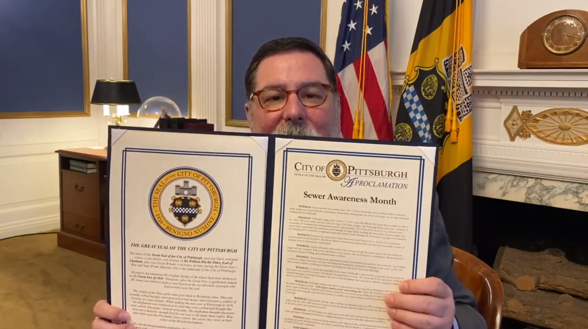 Pittsburgh Mayor William Peduto, holding the proclomation that names August Sewer Awareness Month.