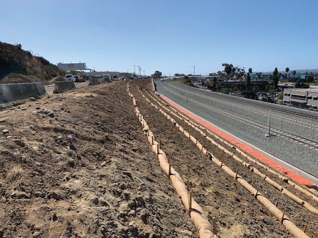 The progression of work along the railway started with a slope prepped for application.