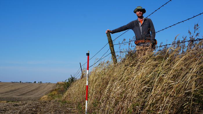 Isaac Larsen standing on the erosional escarpment at Stinton Prairie, Iowa.