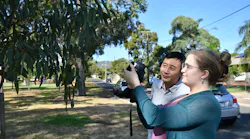 Associate Professor Huade Guan and Xanthia Gleeson use a handheld camera to monitor tree growth.