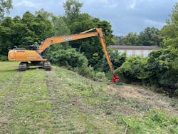 Weber and his team stationed their 63,000-pound Case CX250D long reach excavator with a Fecon Bull Hog forestry mulching attachment at the top of the slope. With this setup, the Case’s fully extended boom arm could easily reach the elm and cherry trees and nuisance vegetation on the slope. Weber and his team stationed their 63,000-pound Case CX250D long reach excavator with a Fecon Bull Hog forestry mulching attachment at the top of the slope. With this setup, the Case’s fully extended boom arm could easily reach the elm and cherry trees and nuisance vegetation on the slope.