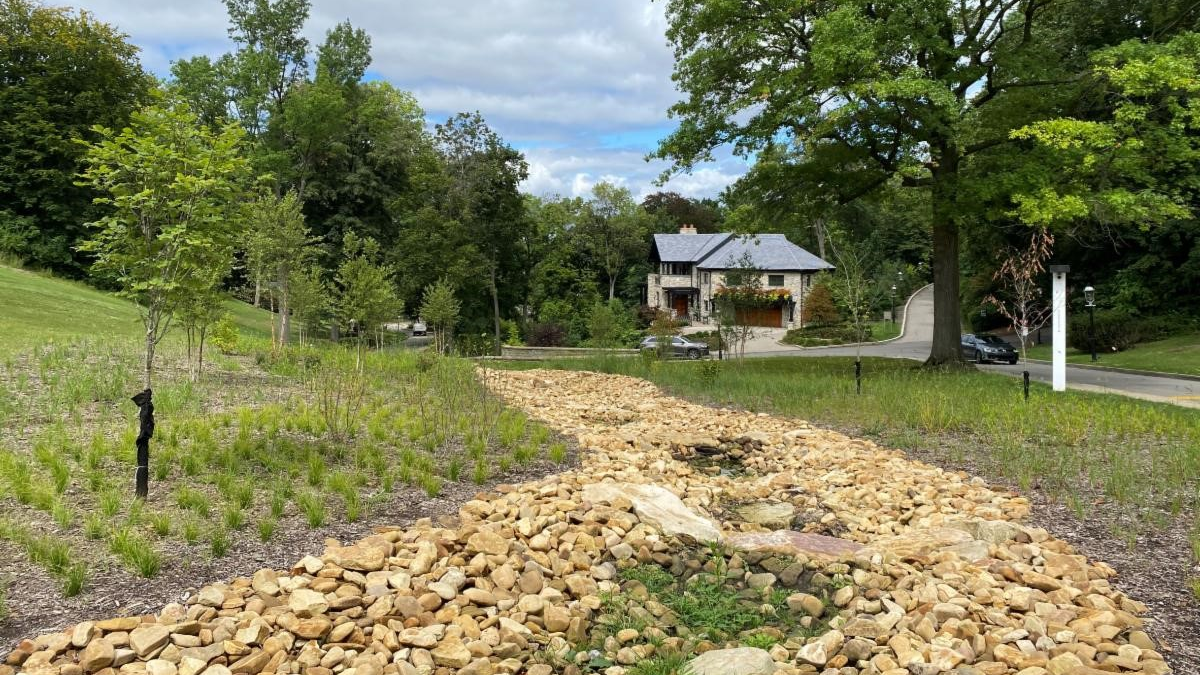 The dry stream bed, located along Woodland Road on Chatham University's campus works in tandem with underground storage to slowly release stormwater into the sewer system. The stones, engineered soils, and plants within the streambed mimic nature helping to slow stormwater runoff.