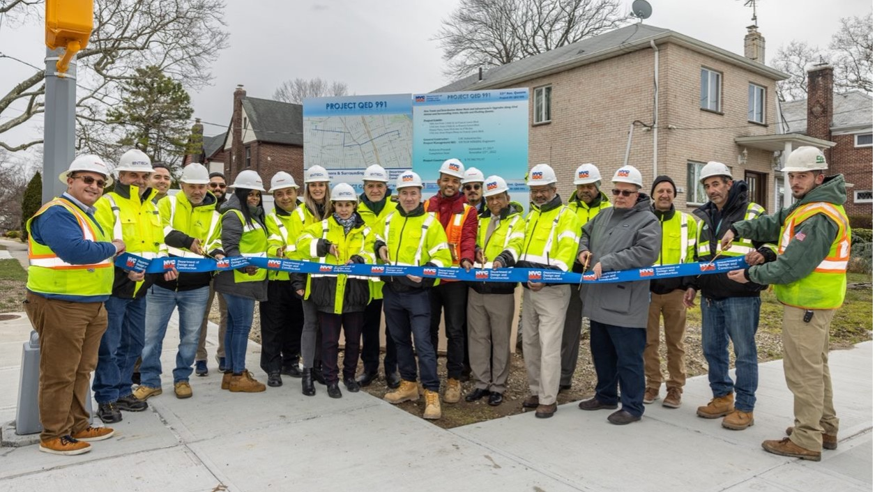 DDC Commissioner Thomas Foley (center), the DDC project team, consultants and contractors celebrate the completion of the $79.7 million project that rebuilt 3.5 miles of streets along 33rd, 37th and 38th Avenues.