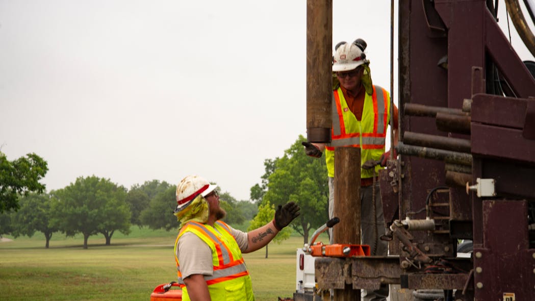 Driller Chris Bean waits to receive pipping while Lead Driller Dallas Spencer operates the controls in June while conducting soil borings along the Trinity River near downtown Fort Worth.