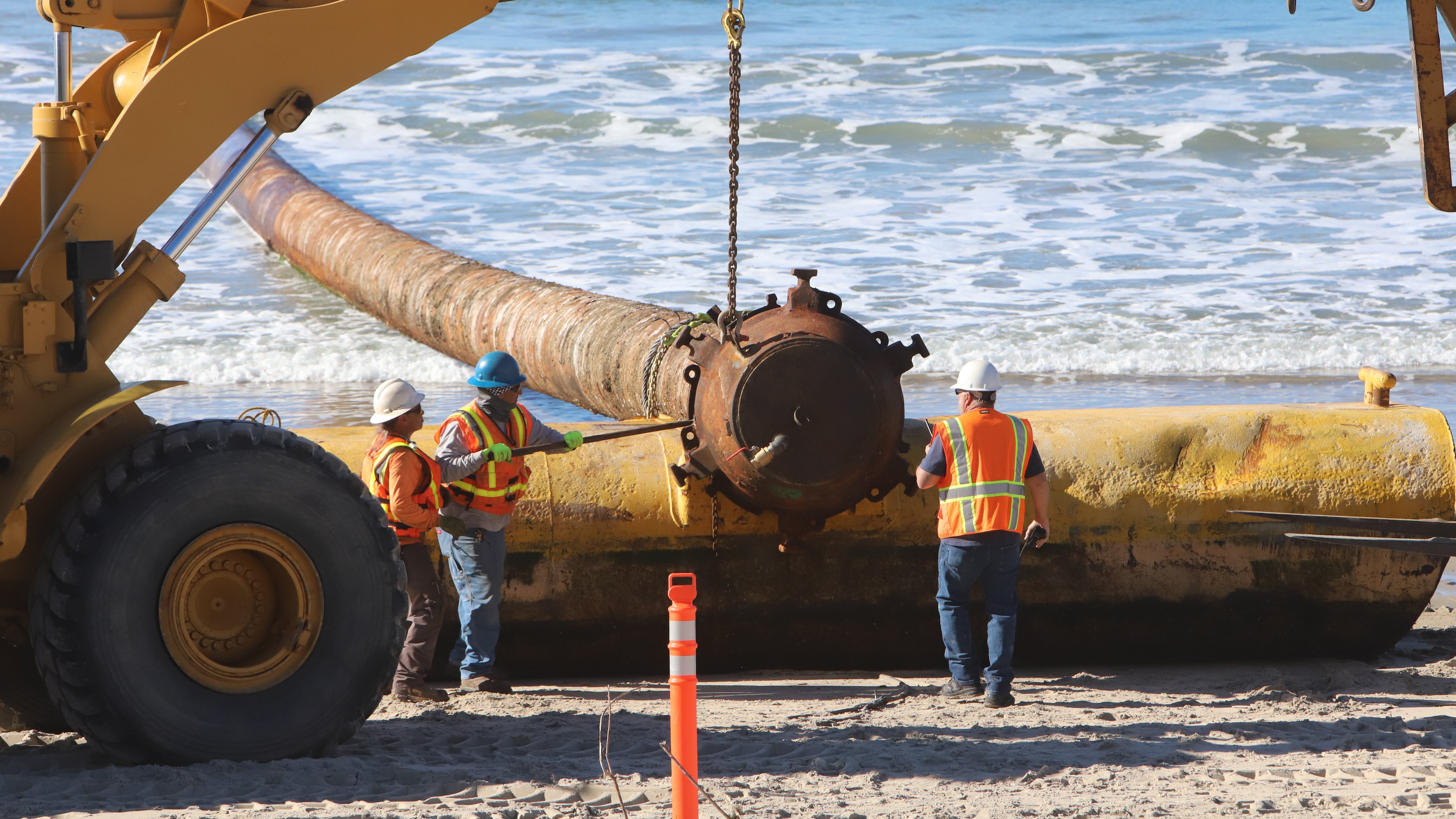 Crews from USACE contractor, Manson Construction, prepare to remove beach end of massive sand pipeline.