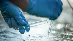 Pond water pollution concept. Scientist takes samples of dirty water from a pond into a test tube. Pond water pollution concept. Scientist takes samples of dirty water from a pond into a test tube.