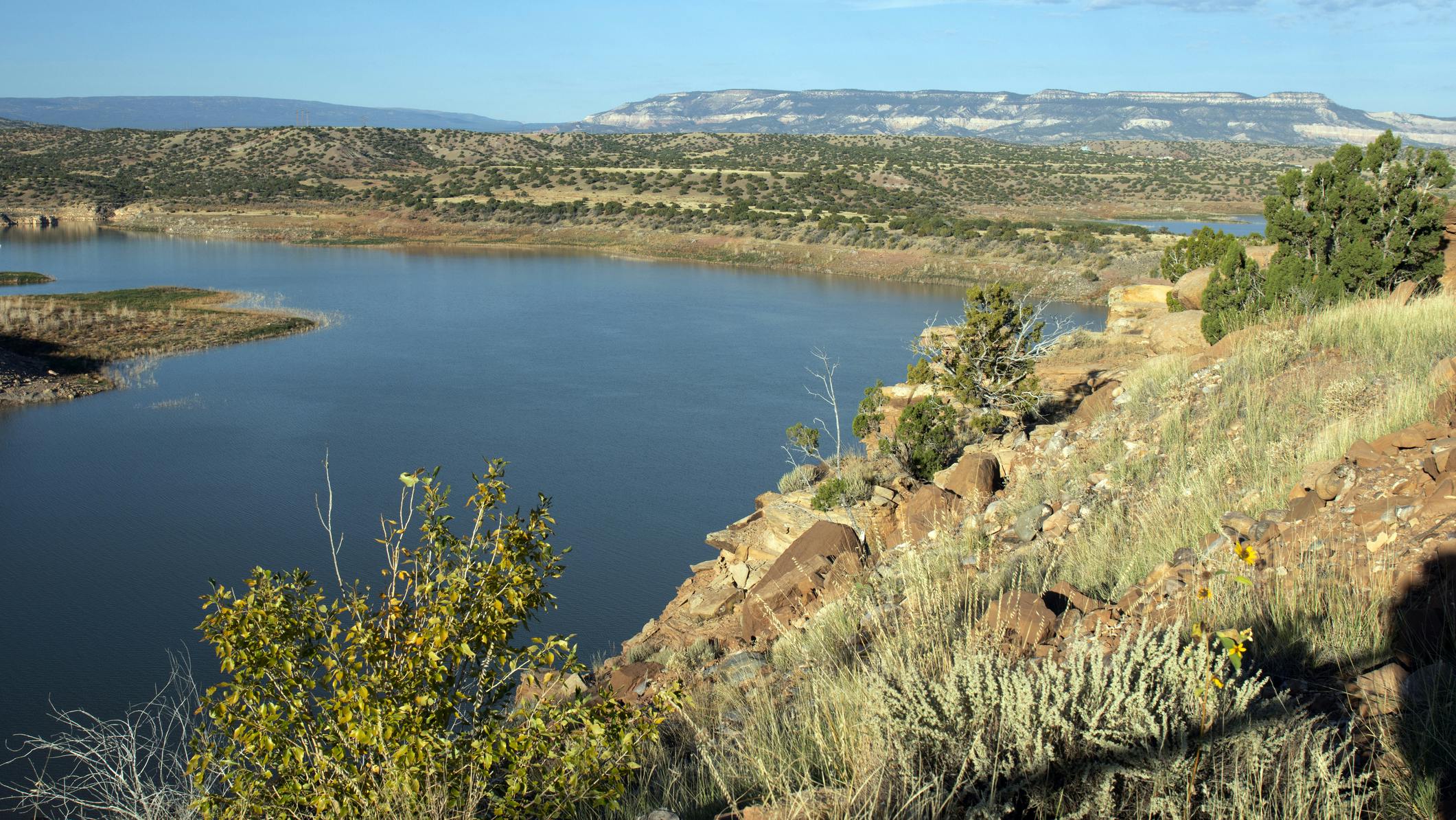 View of Abiquiu Lake, an Army Corps of Engineers reservoir in northern New Mexico, USA, with pinyon and juniper trees at dawn.