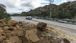 Rockslide Roadway Los Angeles. Los Angeles, California, USA - February 18, 2017: Car passing storm caused rock slide on Santa Susana Pass Road in the San Fernando Valley. Rockslide Roadway Los Angeles. Los Angeles, California, USA - February 18, 2017: Car passing storm caused rock slide on Santa Susana Pass Road in the San Fernando Valley.