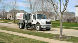Elgin RegenX1 sweeping a street in a residential neighborhood.