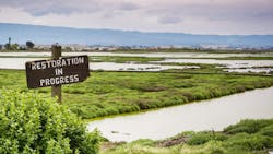 Restoration sign in the wetlands in Alviso Marsh, Don Edwards wildlife refuge, south San Francisco bay, California Restoration sign in the wetlands in Alviso Marsh, Don Edwards wildlife refuge, south San Francisco bay, California