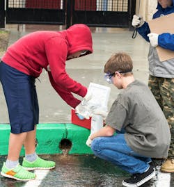 During a rain event, youth in Poseidon Education’s Stormwater Quality Leadership Program collect stormwater runoff samples for laboratory analysis to determine pollutant levels. (Credit: Poseidon Education) During a rain event, youth in Poseidon Education’s Stormwater Quality Leadership Program collect stormwater runoff samples for laboratory analysis to determine pollutant levels. (Credit: Poseidon Education)