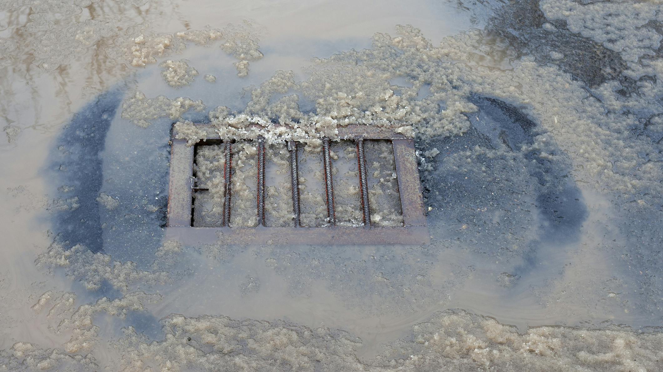 City stormwater drainage covered with snow