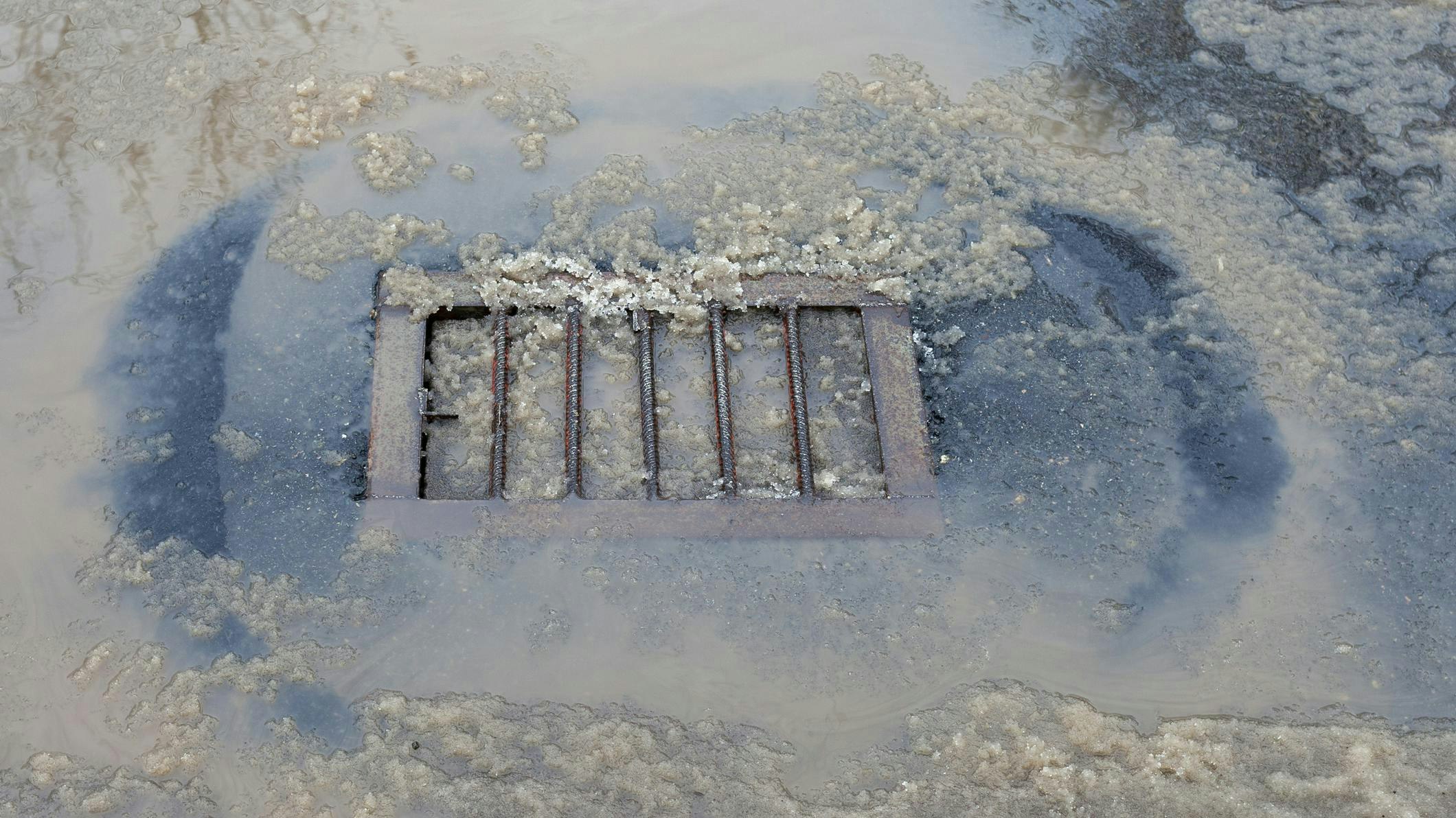City stormwater drainage covered with snow