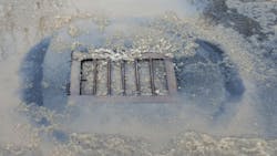 City stormwater drainage covered with snow City stormwater drainage covered with snow