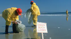 Hazardous material workers cleaning up oil spill, Huntington Beach, CA